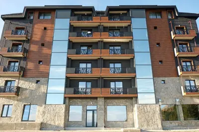 an apartment building with windows and balconies at Vila Golija in Kopaonik