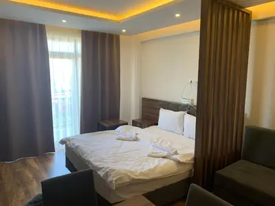 a hotel room with a bed and a chair at President Kop S2 in Kopaonik