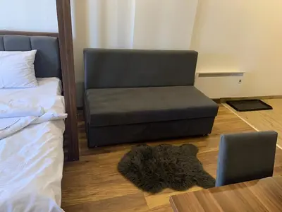 a bedroom with a bed and a chair and a rug at President Kop S2 in Kopaonik
