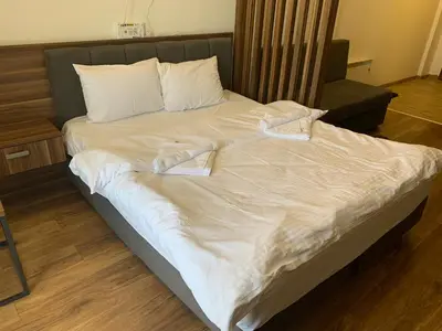 a large white bed with two towels on it at President Kop S2 in Kopaonik