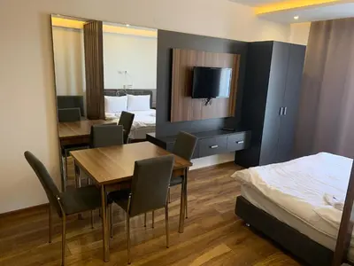 a hotel room with a dining table and a bed at President Kop S2 in Kopaonik