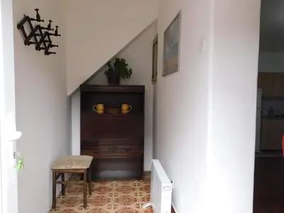 a hallway with a staircase with a chair and a cabinet at Bagdala 2 in Kruševac