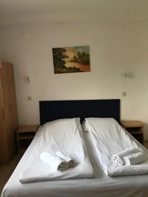 a bed with white sheets and towels on it at VILA ZORICA in Ribarska Banja