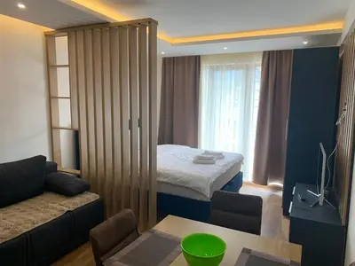 a room with a bed and a couch and a table at President Kop A 735 in Kopaonik