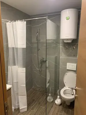 a bathroom with a toilet and a glass shower at President Kop A 735 in Kopaonik