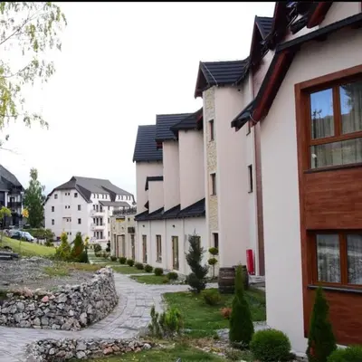 a row of houses in a town with a stone sidewalk at Magic Kop - Milmari Resort in Kopaonik
