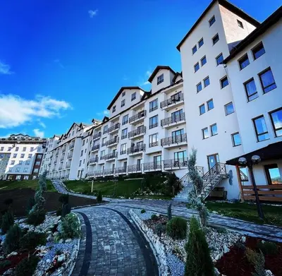 a large apartment building with a pathway in front of it at Magic Kop - Milmari Resort in Kopaonik