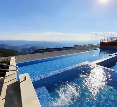 a swimming pool with a view of the mountains at Magic Kop - Milmari Resort in Kopaonik