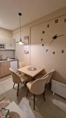 a kitchen with a table and chairs and a clock on the wall at Magic Kop - Milmari Resort in Kopaonik