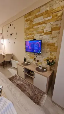 a living room with a tv on a brick wall at Magic Kop - Milmari Resort in Kopaonik