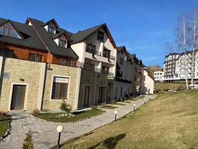 a row of buildings on a hill next to a field at Magic Kop - Milmari Resort in Kopaonik