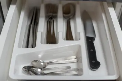 a white tray with silver utensils in a drawer at Tanis Apartments in Niš