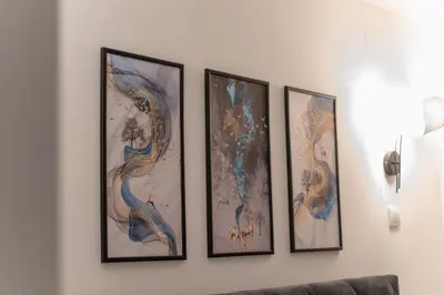 a group of four paintings on a wall at Tanis Apartments in Niš