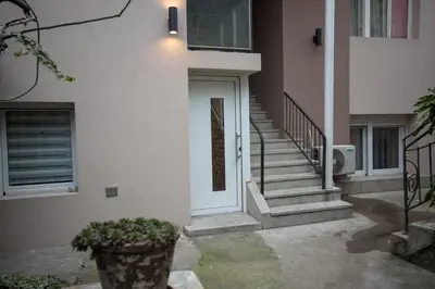 a house with a white door and a stair case at Tanis Apartments in Niš