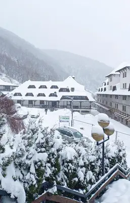 a snow covered parking lot with buildings in the background at Maja Lux Apartman Brzece in Brzeće