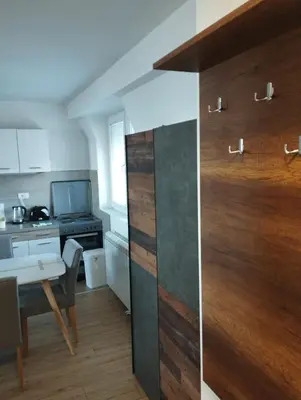 a room with a kitchen with a table and a door at Apartman Iznad Oblaka in Kopaonik
