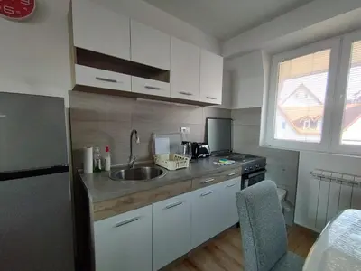 a kitchen with white cabinets and a sink at Apartman Iznad Oblaka in Kopaonik