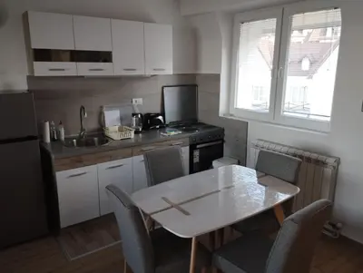 a small kitchen with a table and a sink at Apartman Iznad Oblaka in Kopaonik