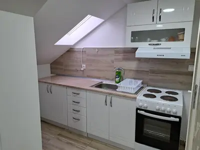 a kitchen with white cabinets and a stove and a sink at Relja in Soko Banja