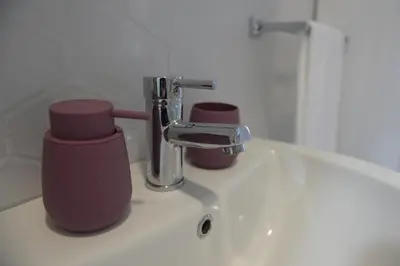 a bathroom sink with two cups and a faucet at MD apartman Vranje FREE PARKING in Vranje