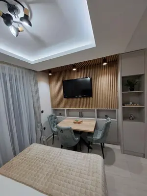 a dining room with a table and a tv on a wall at Lux apartmani Dunja Kopaonik Čardaci - GREEN in Kopaonik