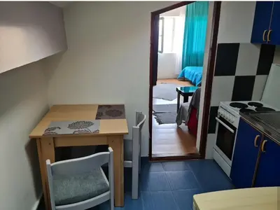 a small kitchen with a small table and a room at City center apartment 3 in Niš