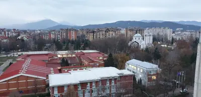 a view of a city with buildings and mountains at City center apartment 3 in Niš