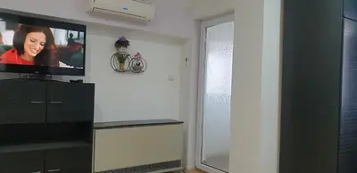 a living room with a flat screen tv on a wall at City center apartment 3 in Niš