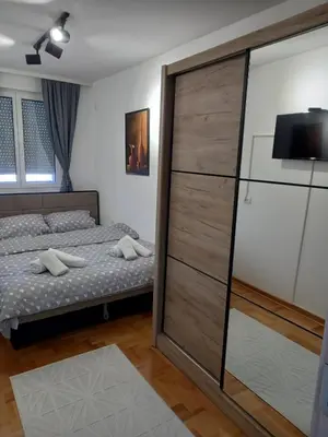 a bedroom with a bed and a large closet at Welcome Apartments in Niš