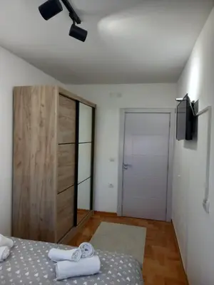 a bedroom with a bed and a wooden door at Welcome Apartments in Niš