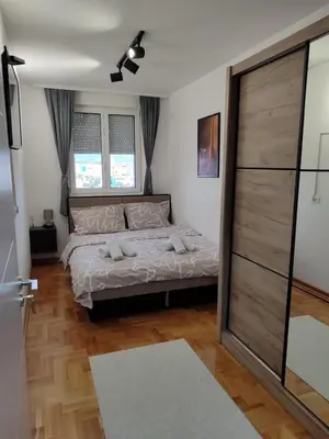 a bedroom with a bed and a ceiling fan at Welcome Apartments in Niš