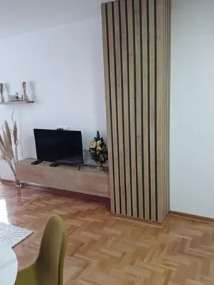 a living room with a partition with a television on it at Welcome Apartments in Niš