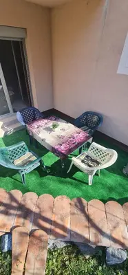 a picnic table and chairs sitting on a lawn at Apartman Pikolo VB in Vrnjačka Banja
