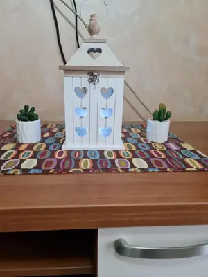 a table with a lantern and two plants on it at Apartman Pikolo VB in Vrnjačka Banja