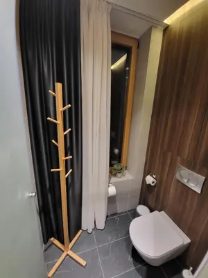 a bathroom with a toilet and a black shower curtain at Woodside 430 Apartment in Kopaonik