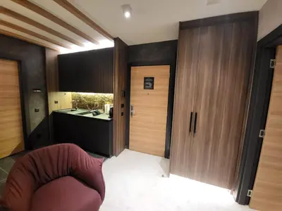 a living room with a red chair and a bathroom at Woodside 430 Apartment in Kopaonik