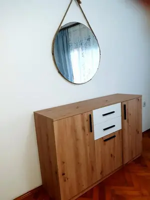 a mirror on top of a wooden cabinet at Apartment Ljiljan 2 Niš in Niš
