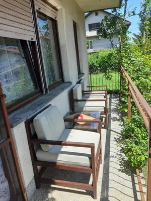 a row of chairs sitting on a porch at Apartment Ljiljan 2 Niš in Niš