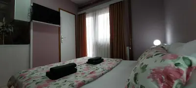 a bedroom with a bed with two black bags on it at KOSA APARTMAN in Vrnjačka Banja