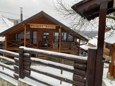 a log cabin with a fence in the snow at Rtanjska kućica in Boljevac