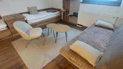 a room with a bed and a table and chairs at Apartman 109 Vila Nikola in Kopaonik