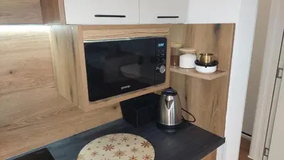 a kitchen with a microwave and a coffee maker on a counter at Apartman 109 Vila Nikola in Kopaonik