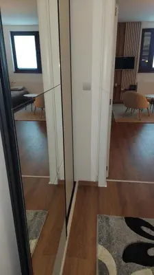 a hallway with a mirror and a room with a table at Apartman 109 Vila Nikola in Kopaonik