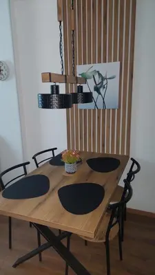 a wooden table with four chairs and ahibition at Apartman 109 Vila Nikola in Kopaonik