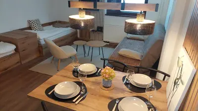 a dining room with a table and a living room at Apartman 109 Vila Nikola in Kopaonik