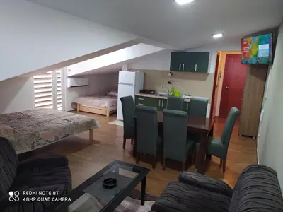 a living room and kitchen with a table and chairs at Apartman Studio AGAPE in Vrnjačka Banja