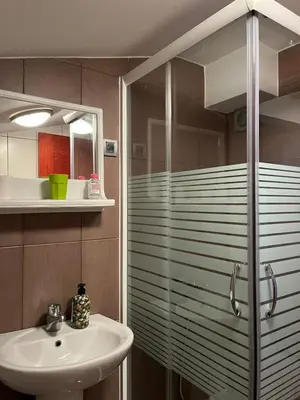 a bathroom with a glass shower and a sink at Apartman Studio AGAPE in Vrnjačka Banja