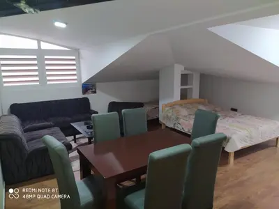 a living room with a table and chairs and a bed at Apartman Studio AGAPE in Vrnjačka Banja