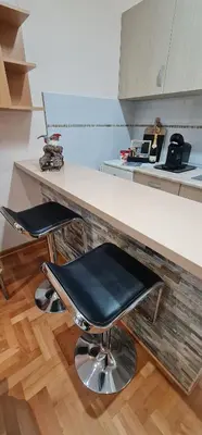 a kitchen with two black chairs at a counter at Design Apartment BUSINESS LUX 4 STAR 