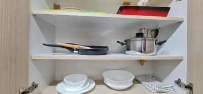 a cupboard with a pot and plates and bowls at Design Apartment BUSINESS LUX 4 STAR 